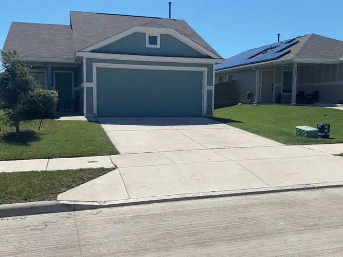 Tidy front lawn and edged driveway at a grey two-story home