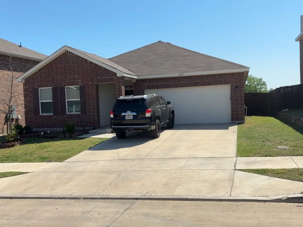 JT Land and Lawn work truck parked at a Fort Worth home after a lawn service