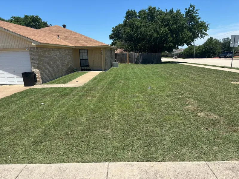 Freshly mowed front lawn with clean mowing stripes in Saginaw, TX
